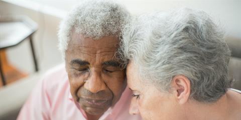 elder couple leaning their heads together